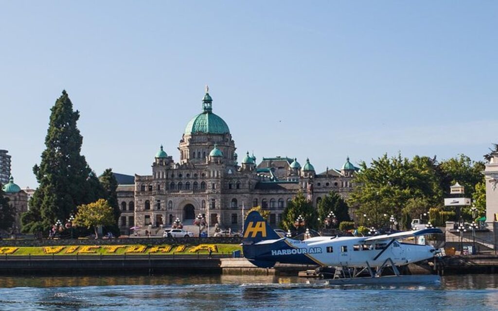 A Victoria seaplane docks in front of the BC Parliament Buildings, Victoria, BC