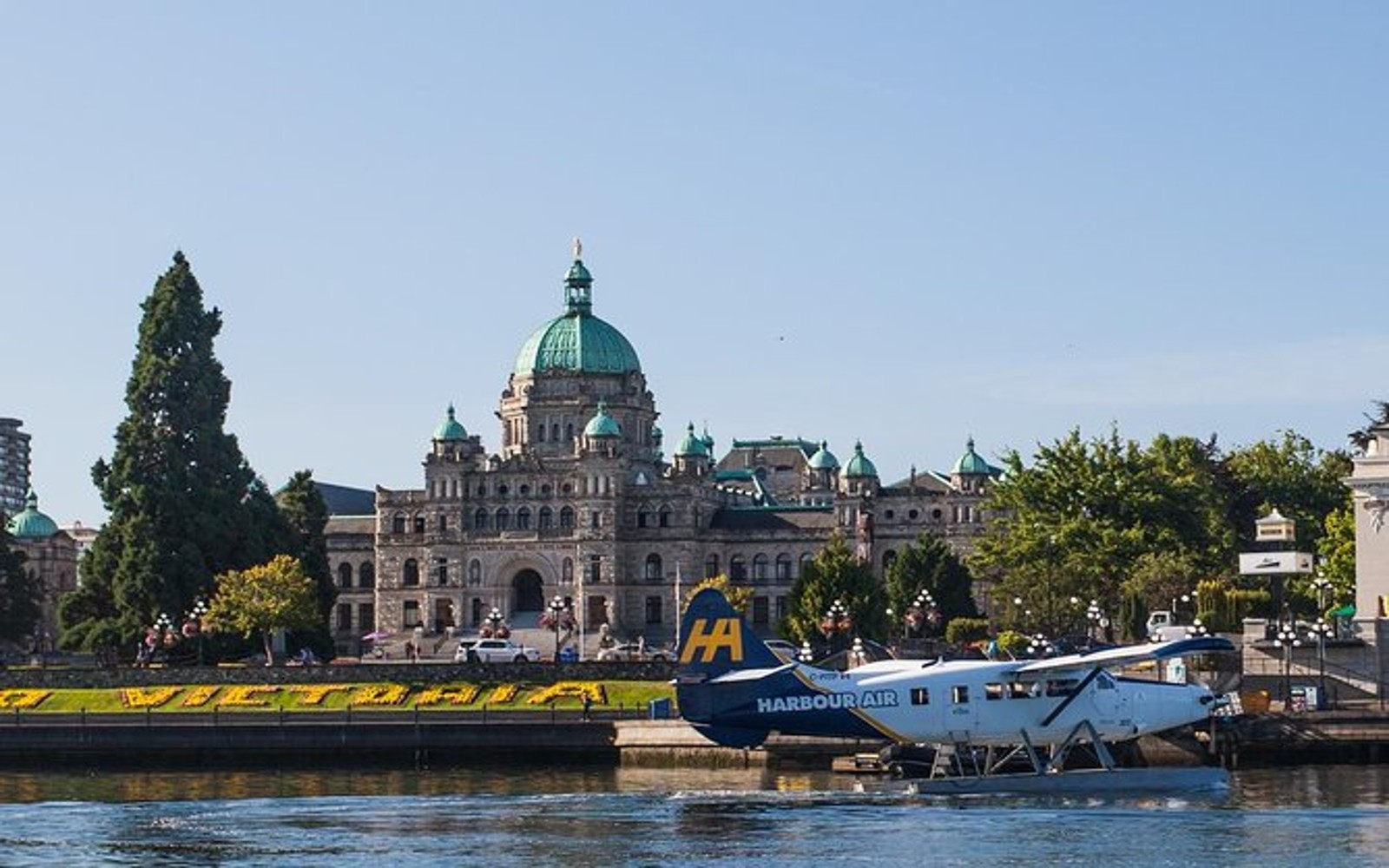 A Vancouver to Victoria seaplane docks in front of the BC Parliament Buildings, Victoria, BC