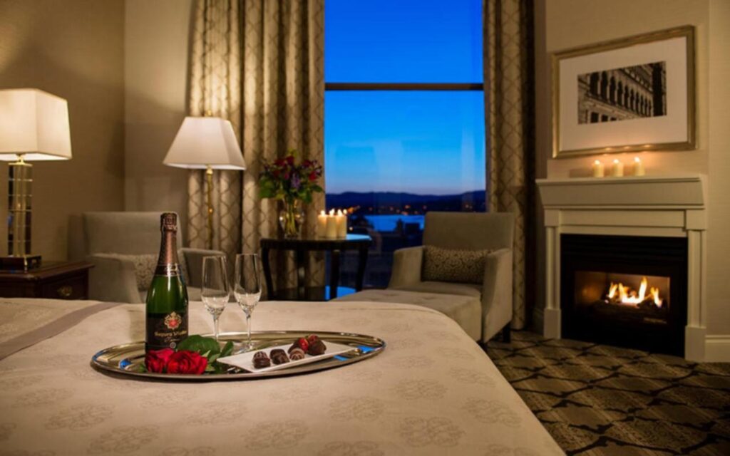 a romantic room with a fireplace and a harbour view at the magnolia hotel, one of the best hotels in victoria