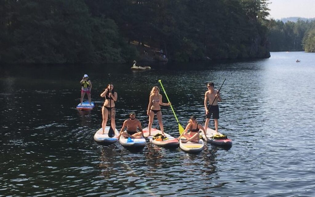 a group enjoys paddleboarding victoria on the paddling thetis lake tour.