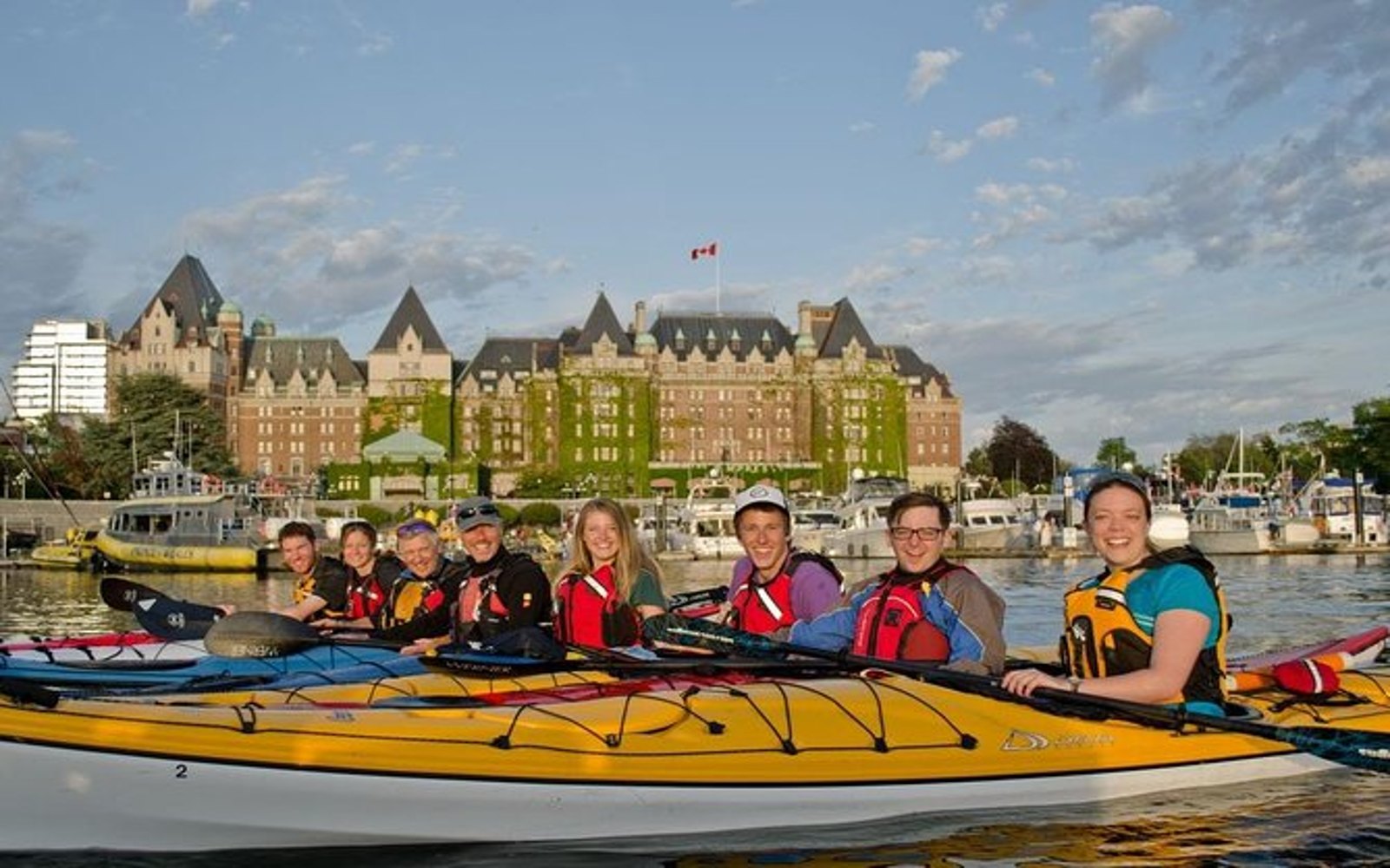 a group of participants on a victoria kayak tour pose in front of the empress hotel