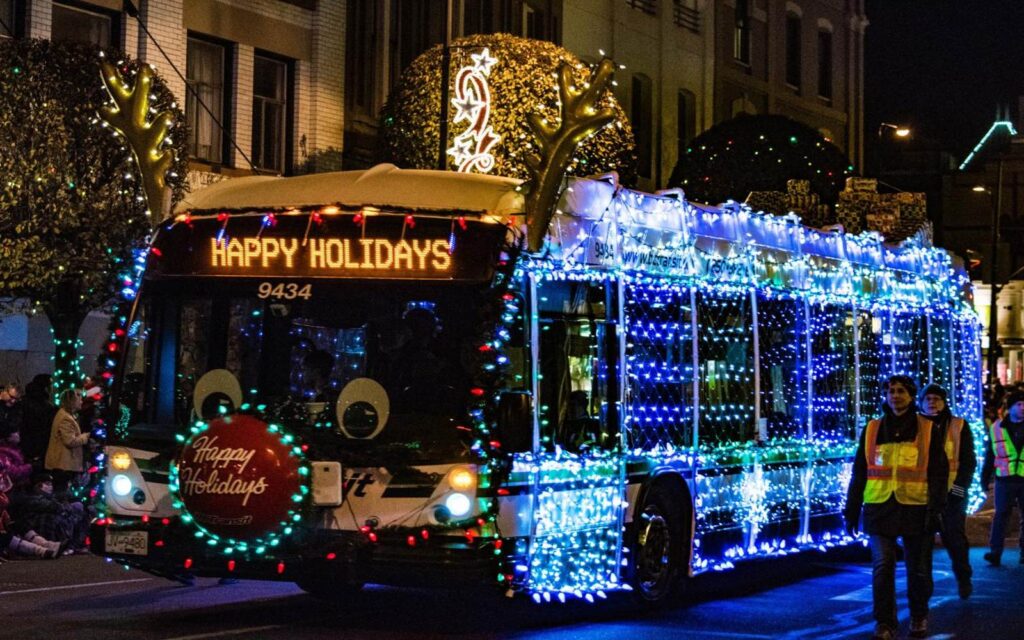 a bus in holiday decor during the victoria santa claus parade.