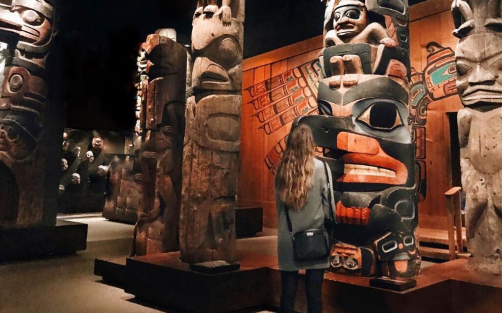 A woman admires a totem pole at the Royal BC Museum in Victoria, BC.